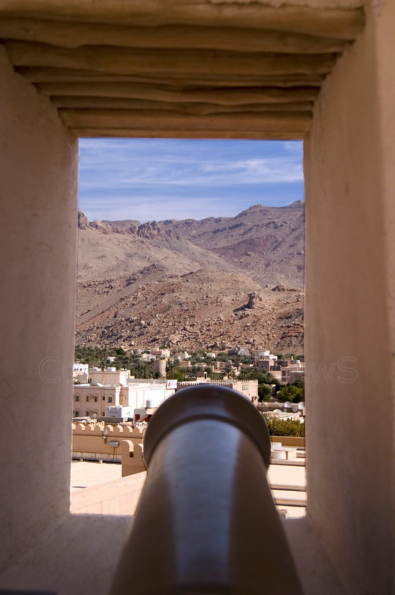 Nizwa Fort window cannon view 
 Desert & town view framed by Nizwa Fort window 
 Keywords: Nizwa, Fort, Canon, Scenery, View