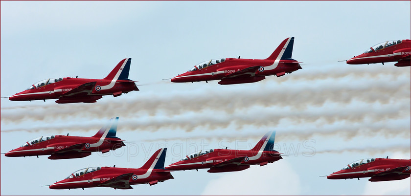 Red Arrows 02255 
 Red Arrows in action, tight horizontal formation with pilot clearly visible making thumbs up sign on top right 
 Keywords: Red Arrows, Farnborough airshow, July 2010